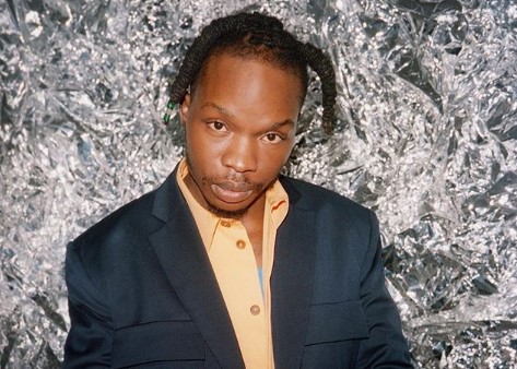 Naira Marley Commends Cameroonian Who Tattooed His Name On Her Chest (Video)